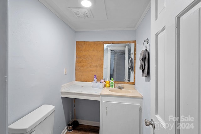 bathroom with ornamental molding, vanity, and toilet