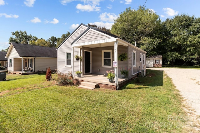 bungalow-style house featuring a front lawn, an outdoor structure, and covered porch