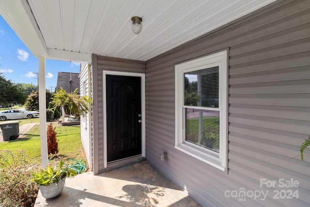 entrance to property featuring a lawn