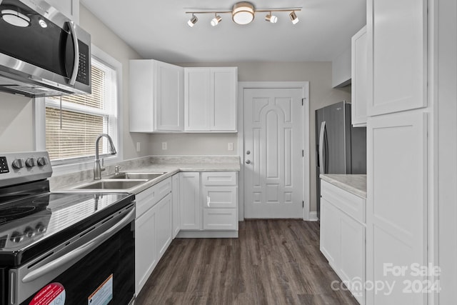 kitchen with dark wood-type flooring, white cabinetry, light countertops, and appliances with stainless steel finishes