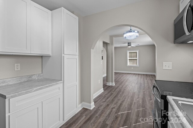 kitchen featuring stainless steel appliances, white cabinets, ceiling fan, and dark hardwood / wood-style floors