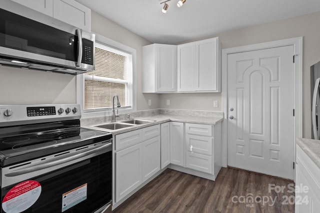 kitchen featuring light countertops, a sink, white cabinetry, appliances with stainless steel finishes, and dark wood-style flooring