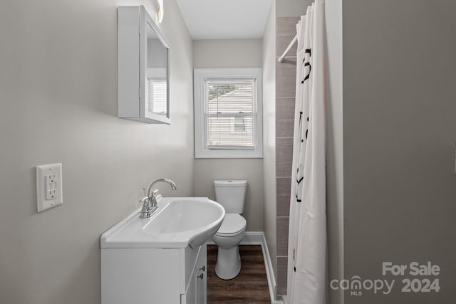 full bathroom featuring a shower with shower curtain, toilet, vanity, wood finished floors, and baseboards
