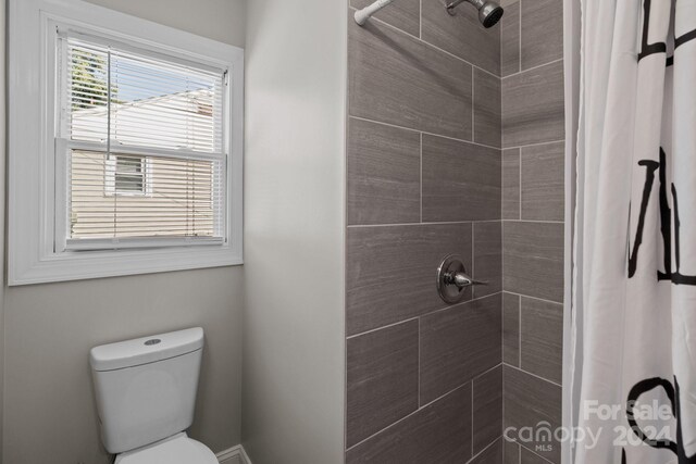 bathroom featuring toilet and a shower with shower curtain