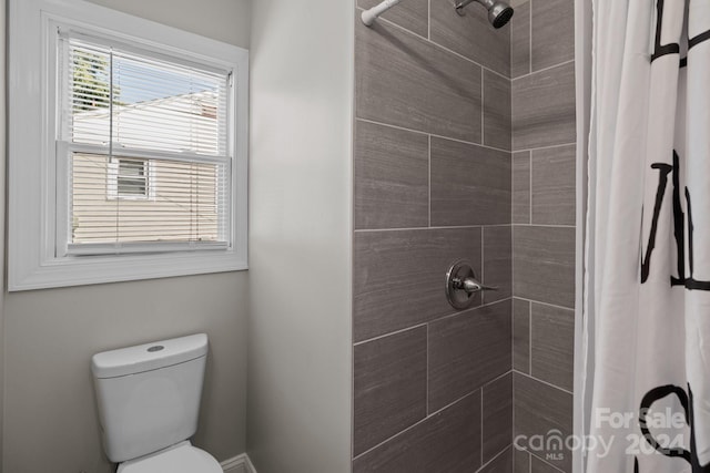 full bath with toilet and tiled shower