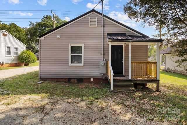 rear view of house featuring a yard