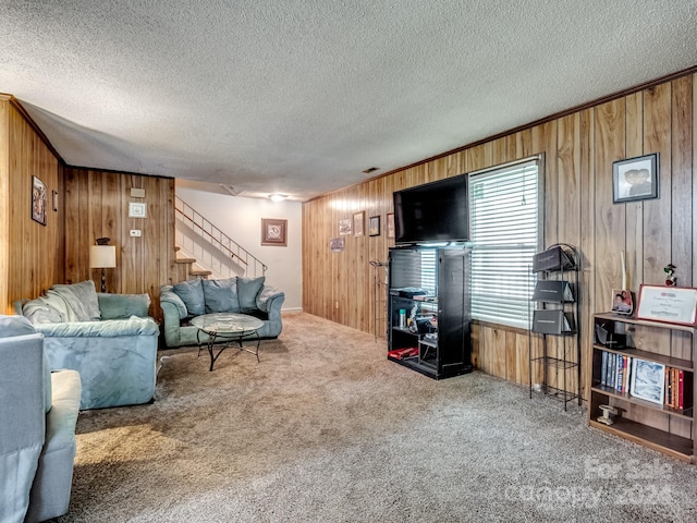 carpeted living room featuring a textured ceiling and wooden walls