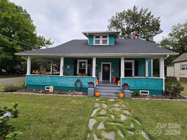 view of front of house with a porch and a front lawn