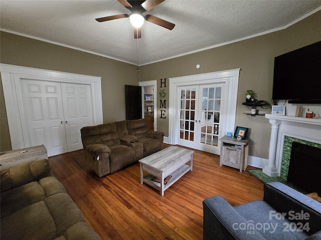 living room with ceiling fan, french doors, wood-type flooring, a textured ceiling, and a premium fireplace