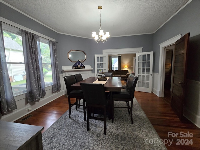 dining space featuring a textured ceiling, a chandelier, dark wood-type flooring, and a wealth of natural light