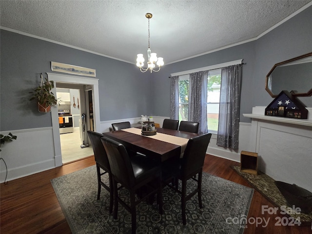 dining space with ornamental molding, a textured ceiling, dark hardwood / wood-style floors, and an inviting chandelier