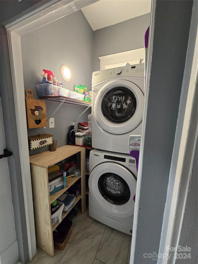 clothes washing area featuring stacked washing maching and dryer