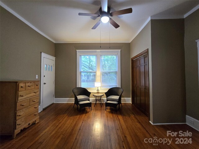 sitting room with ornamental molding, ceiling fan, and dark wood-type flooring