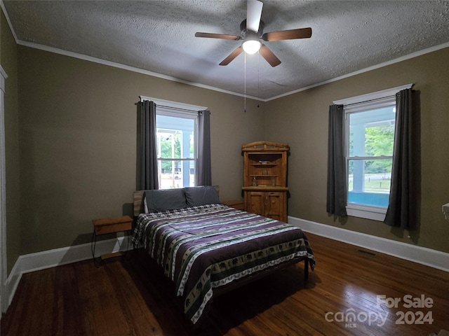 bedroom featuring ceiling fan, a textured ceiling, dark hardwood / wood-style flooring, and multiple windows