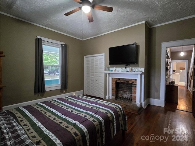 bedroom with ceiling fan, ornamental molding, a textured ceiling, a closet, and dark hardwood / wood-style flooring