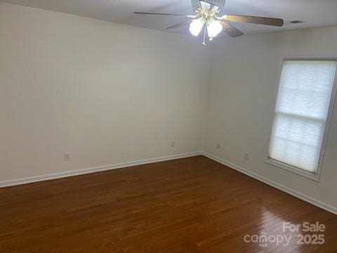 empty room featuring dark wood-type flooring and ceiling fan