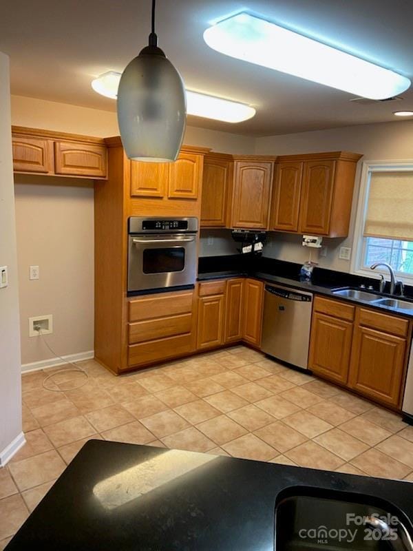 kitchen featuring stainless steel appliances, sink, hanging light fixtures, and light tile patterned floors