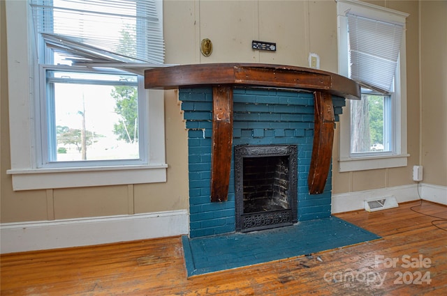 interior details with a brick fireplace and wood-type flooring