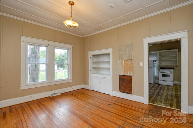 unfurnished bedroom featuring white refrigerator, hardwood / wood-style flooring, and crown molding