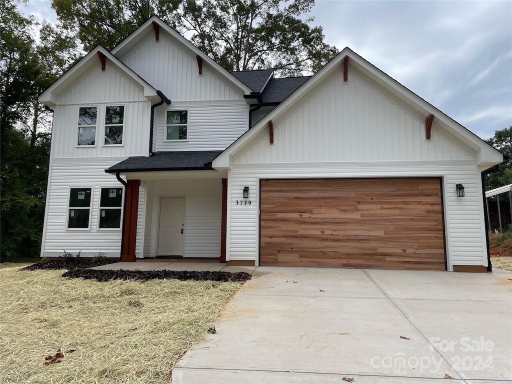 view of front of home with a front lawn, a porch, and a garage