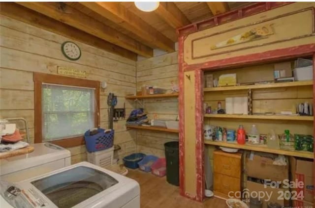 interior space featuring wooden walls, hardwood / wood-style floors, and washer and dryer