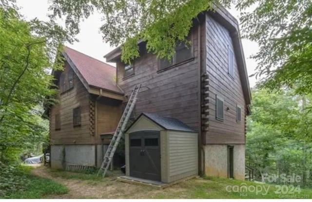 rear view of property featuring a storage shed