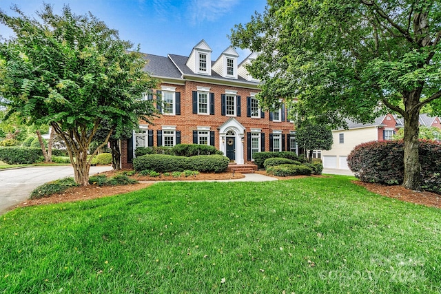 colonial inspired home featuring a front lawn