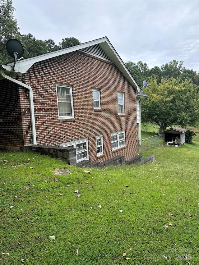 view of side of property with brick siding and a yard