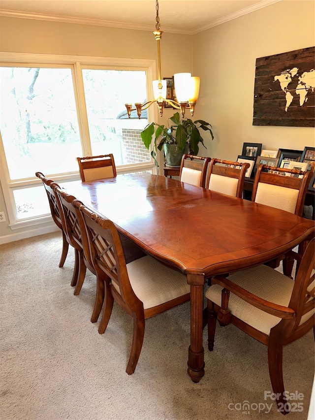 dining room with light colored carpet, crown molding, and an inviting chandelier