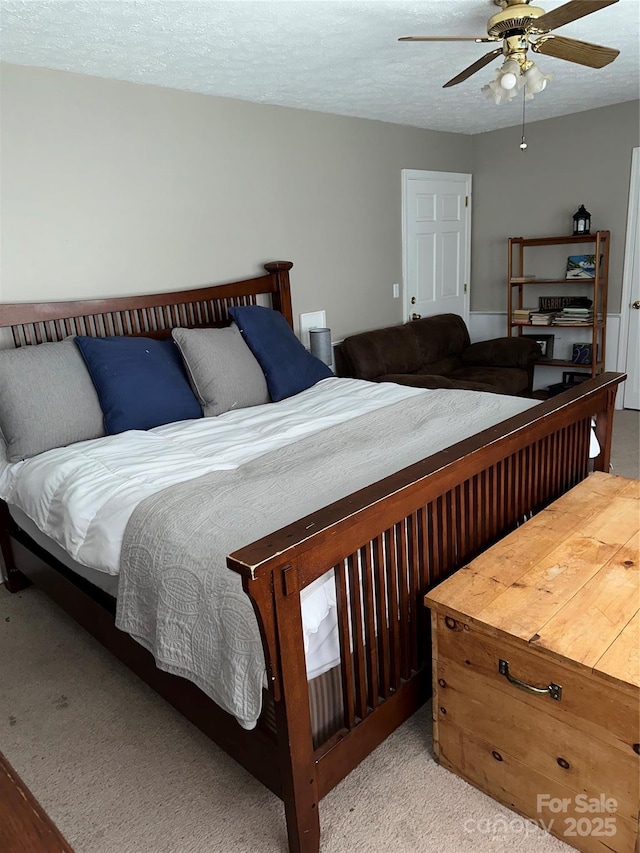 bedroom with a textured ceiling, carpet floors, and a ceiling fan