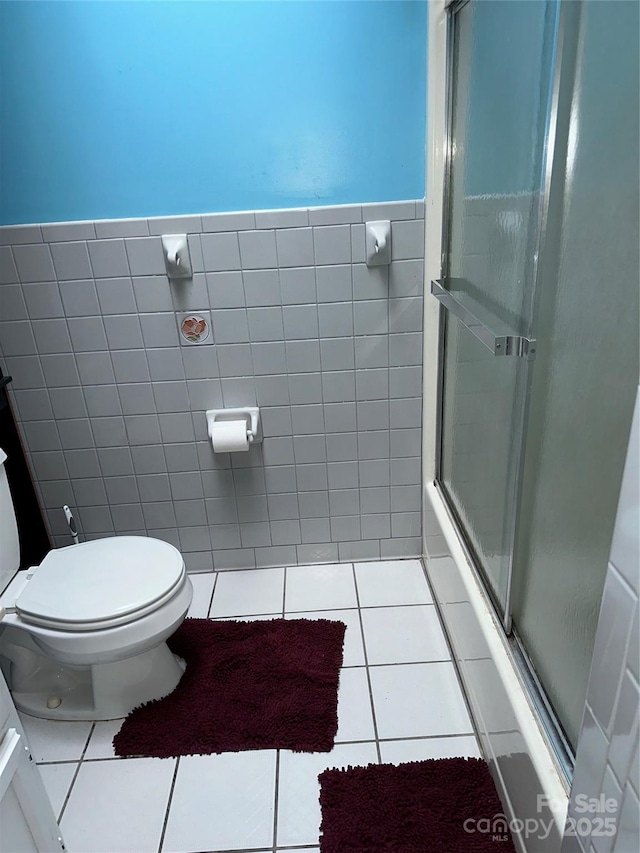 full bath featuring tile patterned flooring, tile walls, and toilet