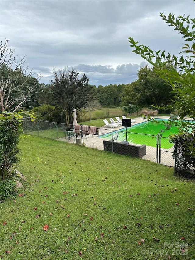 view of property's community featuring a lawn and fence