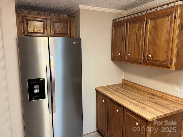 kitchen featuring a textured ceiling, crown molding, brown cabinetry, and stainless steel fridge with ice dispenser