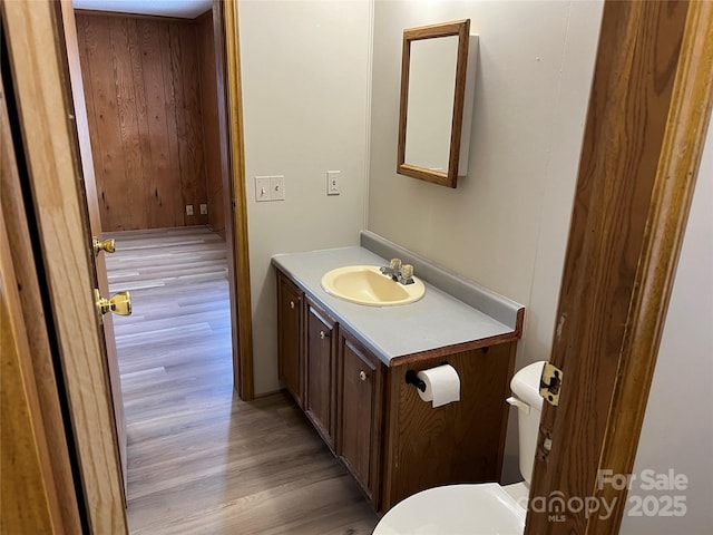 bathroom featuring toilet, wood finished floors, and vanity