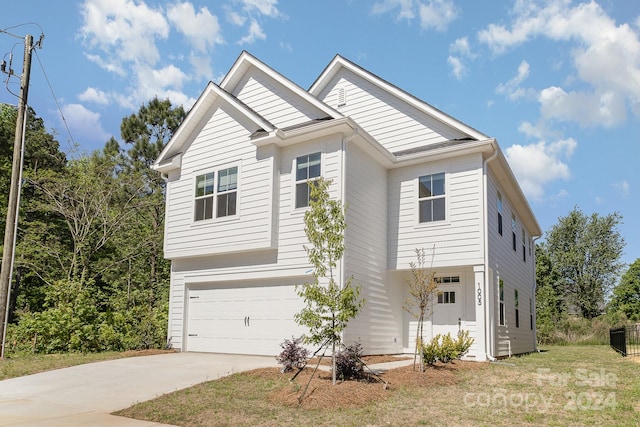 view of front of home with a garage and a front lawn