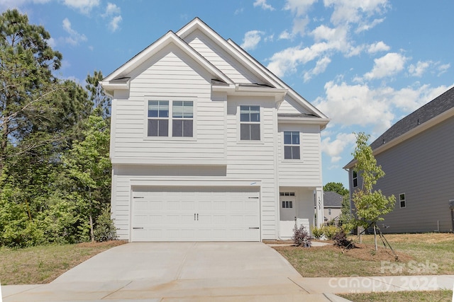 view of front of property featuring a front yard and a garage