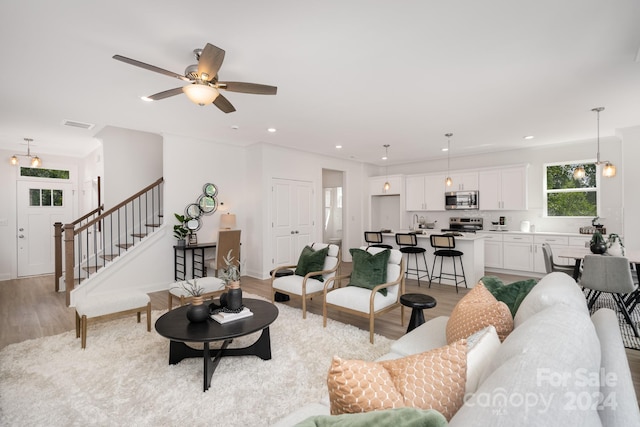 living room with light hardwood / wood-style floors and ceiling fan