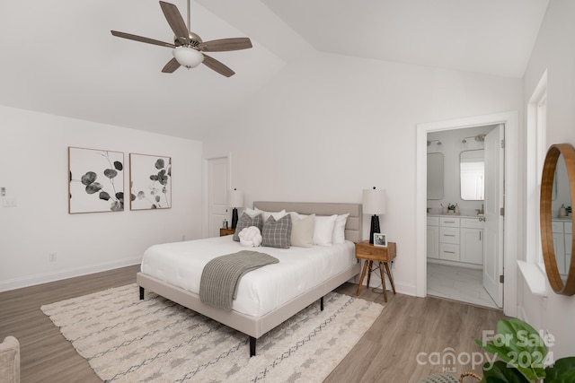 bedroom with ceiling fan, light hardwood / wood-style floors, lofted ceiling, and ensuite bathroom