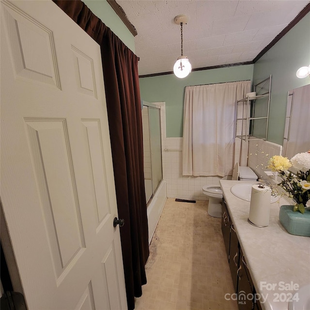 full bathroom with toilet, crown molding, tile walls, bath / shower combo with glass door, and vanity