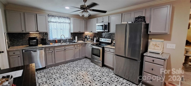 kitchen with gray cabinetry, ceiling fan, sink, backsplash, and appliances with stainless steel finishes