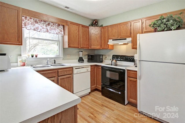 kitchen with black appliances, light wood-type flooring, and sink