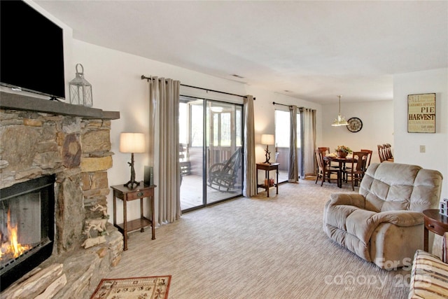 carpeted living room with a stone fireplace