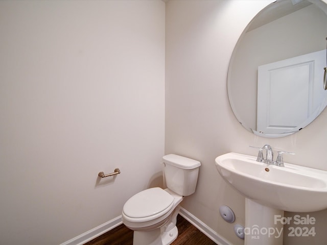 bathroom with toilet, sink, and hardwood / wood-style floors