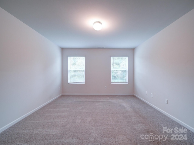 unfurnished room featuring light carpet