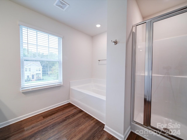 bathroom with hardwood / wood-style floors and separate shower and tub