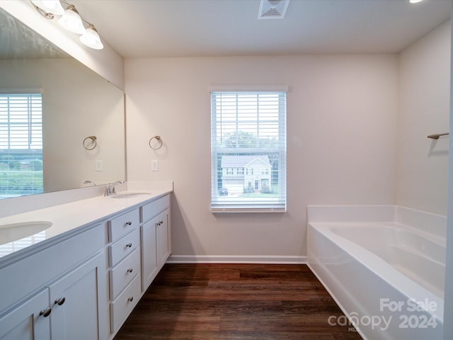 bathroom featuring hardwood / wood-style floors, vanity, and a bathing tub