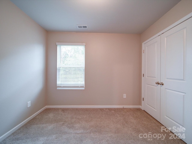 unfurnished bedroom featuring light carpet