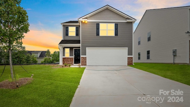 view of front of house with a garage and a lawn