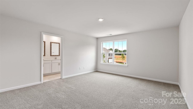 unfurnished bedroom featuring baseboards, connected bathroom, and light colored carpet