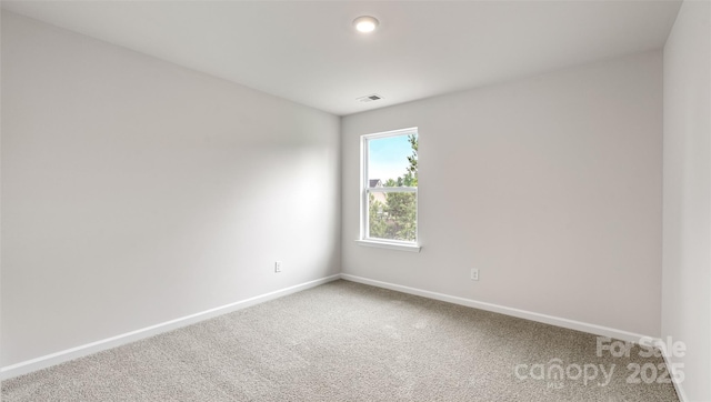 carpeted empty room with visible vents and baseboards